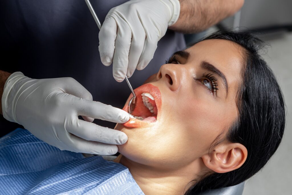 Dentist examining a patient’s gums during a periodontal checkup at Twiss Dental in Highlands Ranch